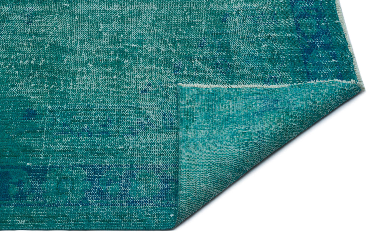 Teal and blue distressed vintage-style rug with a folded corner on a white background.