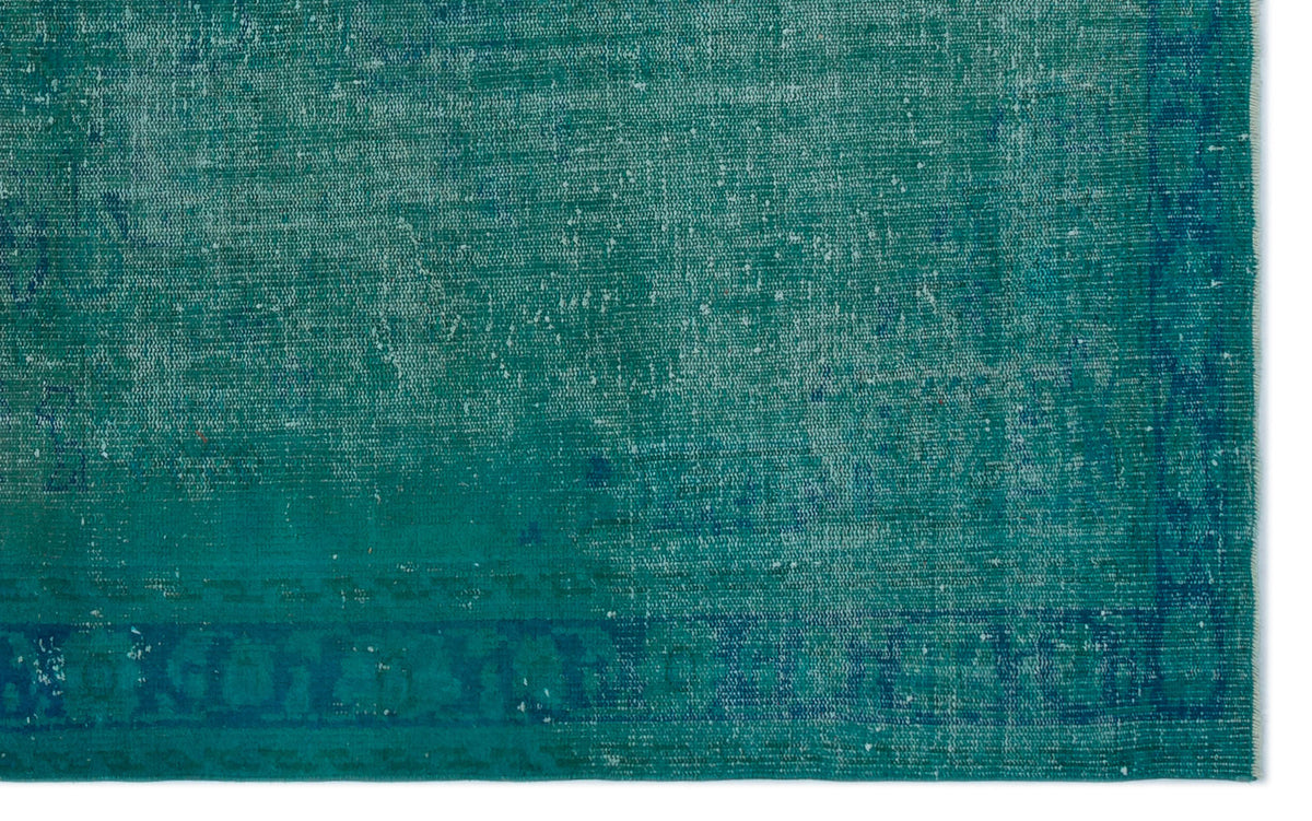 Teal and blue distressed vintage-style rug with a faded, worn texture and a subtle border pattern.