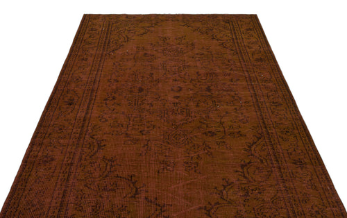 Load image 1 in gallery view. Rust-colored vintage-style rug with a dark, faded traditional floral medallion pattern and a detailed border.