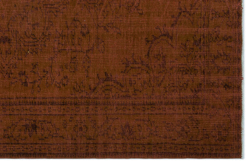 Load image 1 in gallery view. Rust-colored rug with a dark, subtle floral pattern and a visible horizontal weave texture.