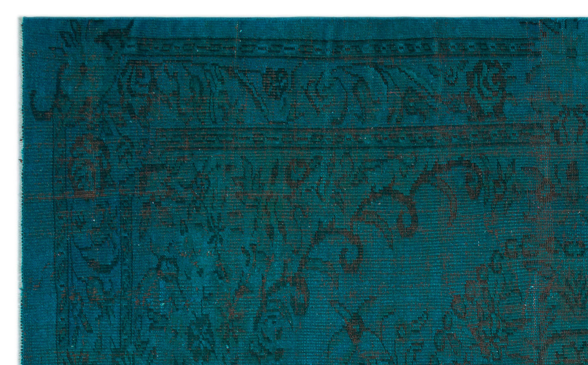Teal rug with a dark, distressed traditional floral medallion pattern and a bordered edge.