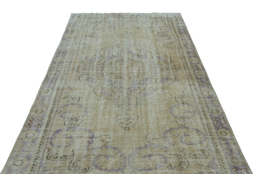 Load image 1 in gallery view. Distressed beige and lavender vintage-style rug with a central medallion and ornate border pattern on a white background.