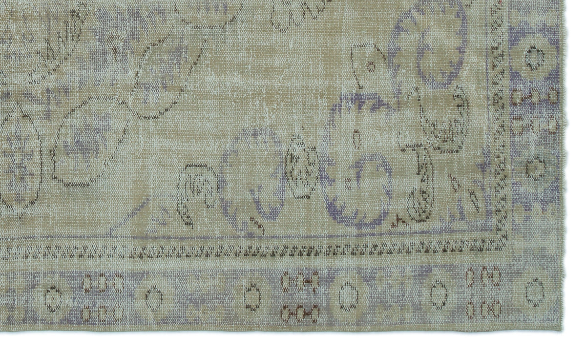 Beige and lavender distressed rug with a faded traditional floral medallion pattern and a bordered edge.