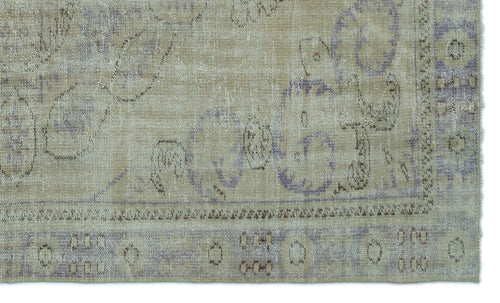 Load image 1 in gallery view. Beige and lavender distressed rug with a faded traditional floral medallion pattern and a bordered edge.