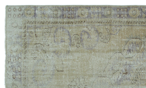Load image 1 in gallery view. Beige and muted purple distressed rug with a faded traditional floral medallion pattern and geometric border.