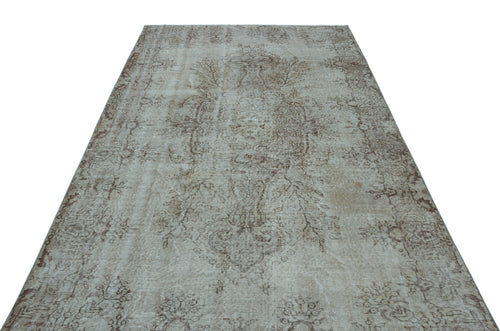 Load image 1 in gallery view. Beige and taupe vintage-style rug with a faded central medallion and intricate floral motifs on a white background.
