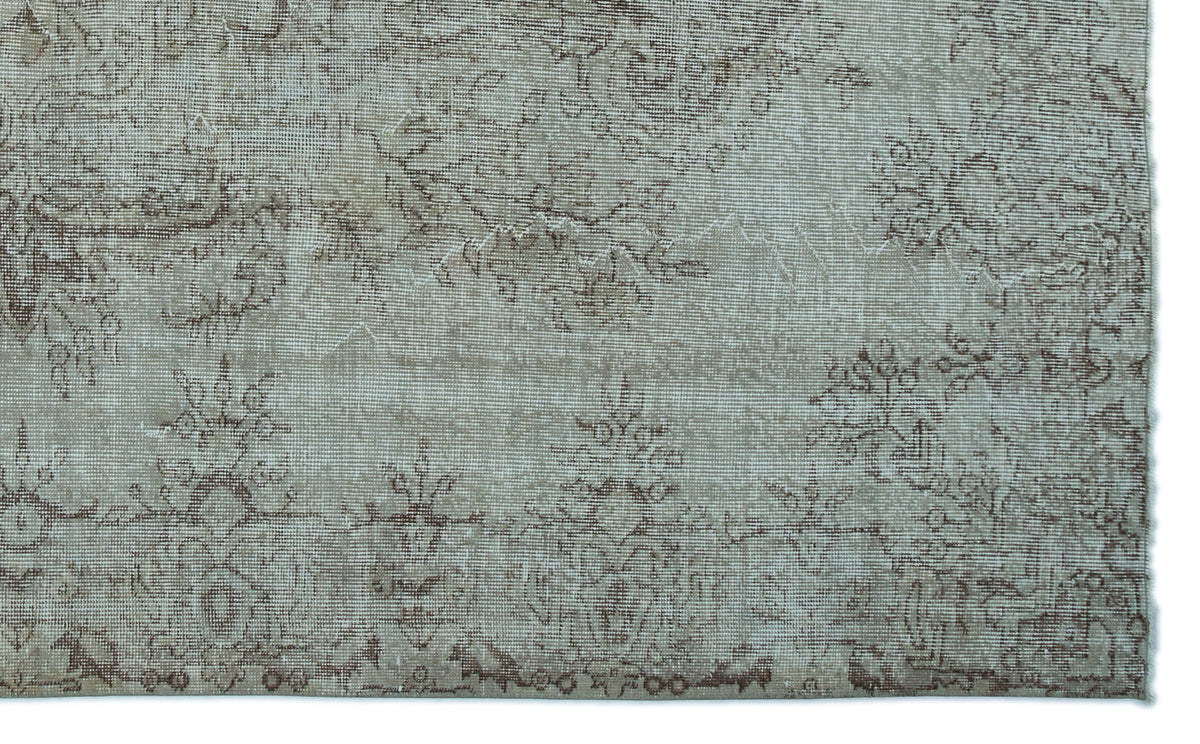 Light gray rug with a faded brown floral medallion pattern and a distressed, vintage-style texture.