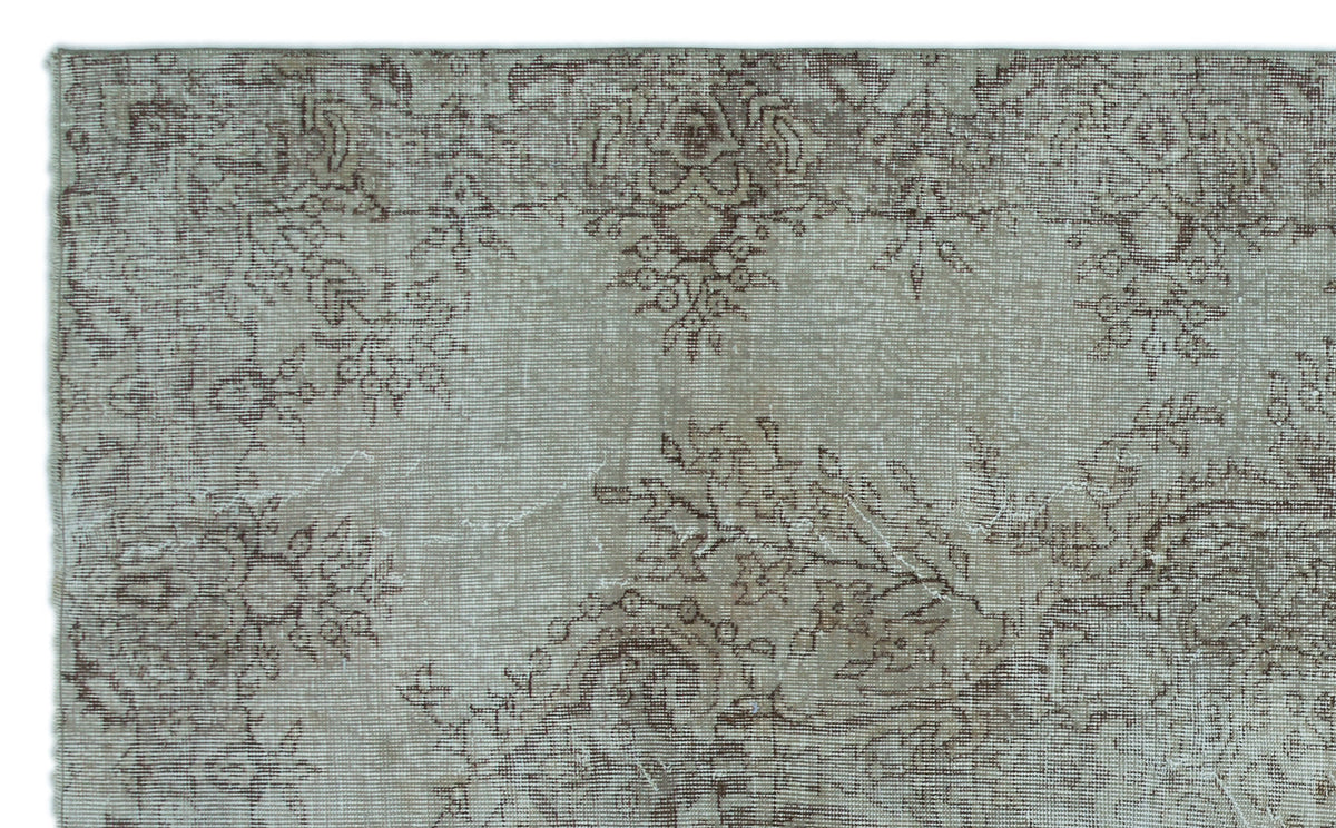 Taupe and brown vintage-style rug with a faded, distressed floral medallion pattern.