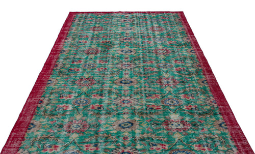 Load image 1 in gallery view. Distressed emerald green rug with a red border and a repeating floral medallion pattern.