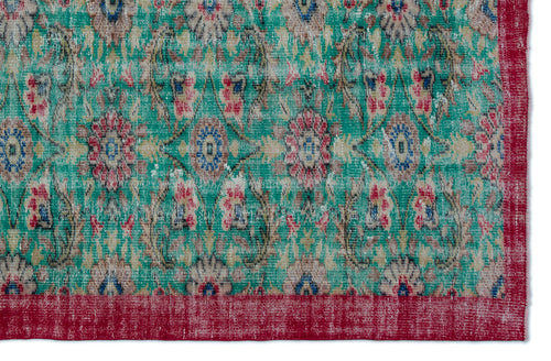 Load image 1 in gallery view. Distressed teal rug with a repeating floral medallion pattern in red, blue, and beige, featuring a solid red border.