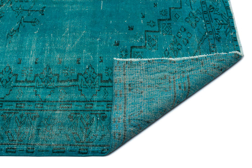 Load image 1 in gallery view. Teal distressed rug with a dark geometric pattern and a folded corner revealing the woven backing.