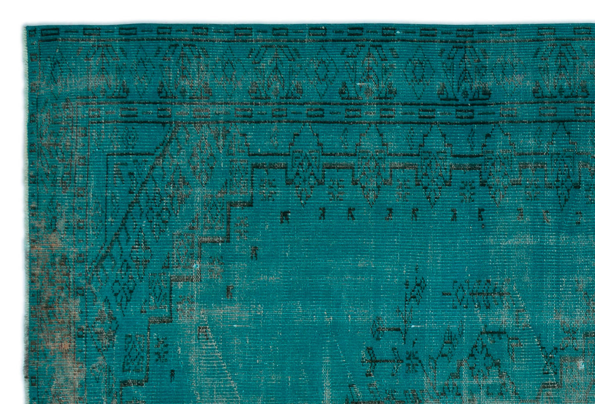 Teal vintage-style rug with a distressed black geometric border and central medallion pattern.