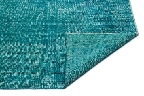 Load image 1 in gallery view. Teal distressed area rug with a faded traditional pattern and a folded corner, isolated on a white background.