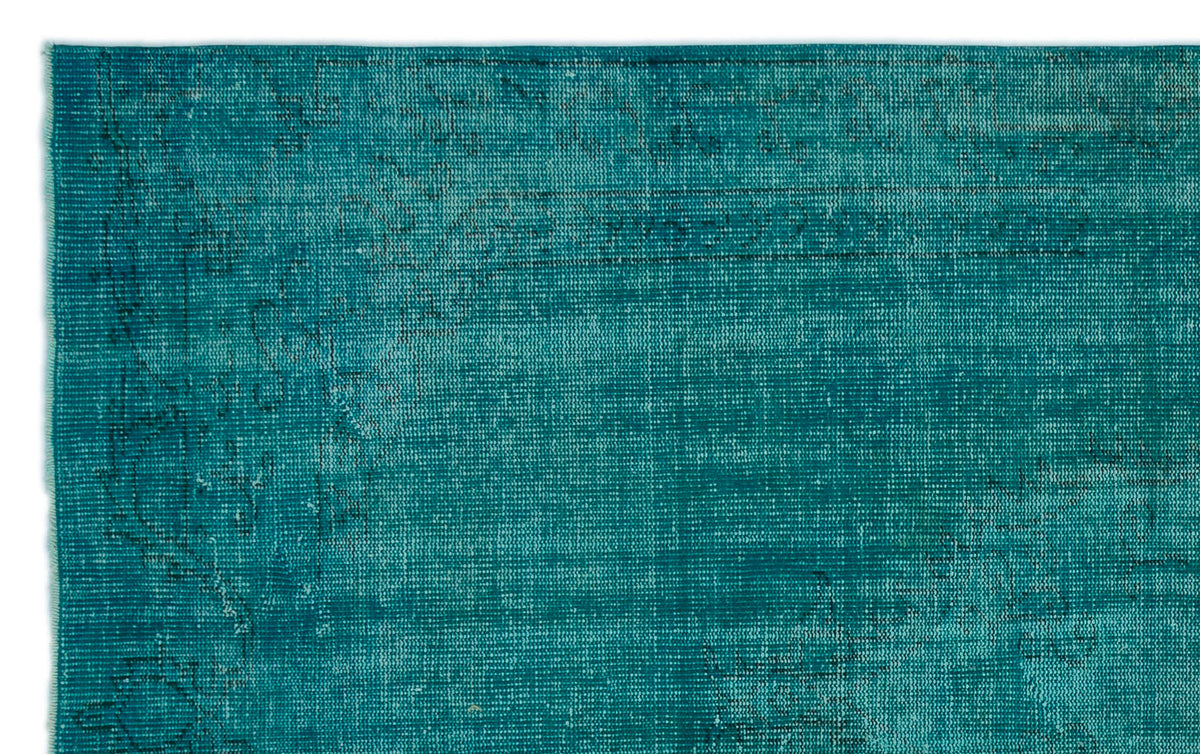 Teal distressed rug with a faded, intricate traditional medallion pattern.