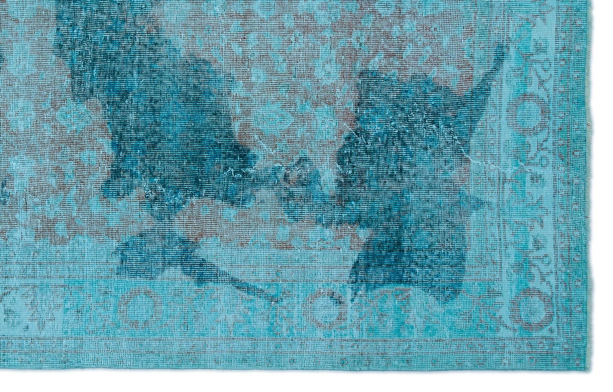 Turquoise and dark blue distressed rug with a faded traditional medallion pattern.