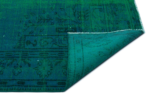 Load image 1 in gallery view. Emerald green rug with a distressed traditional pattern, shown with a corner folded over on a white background.