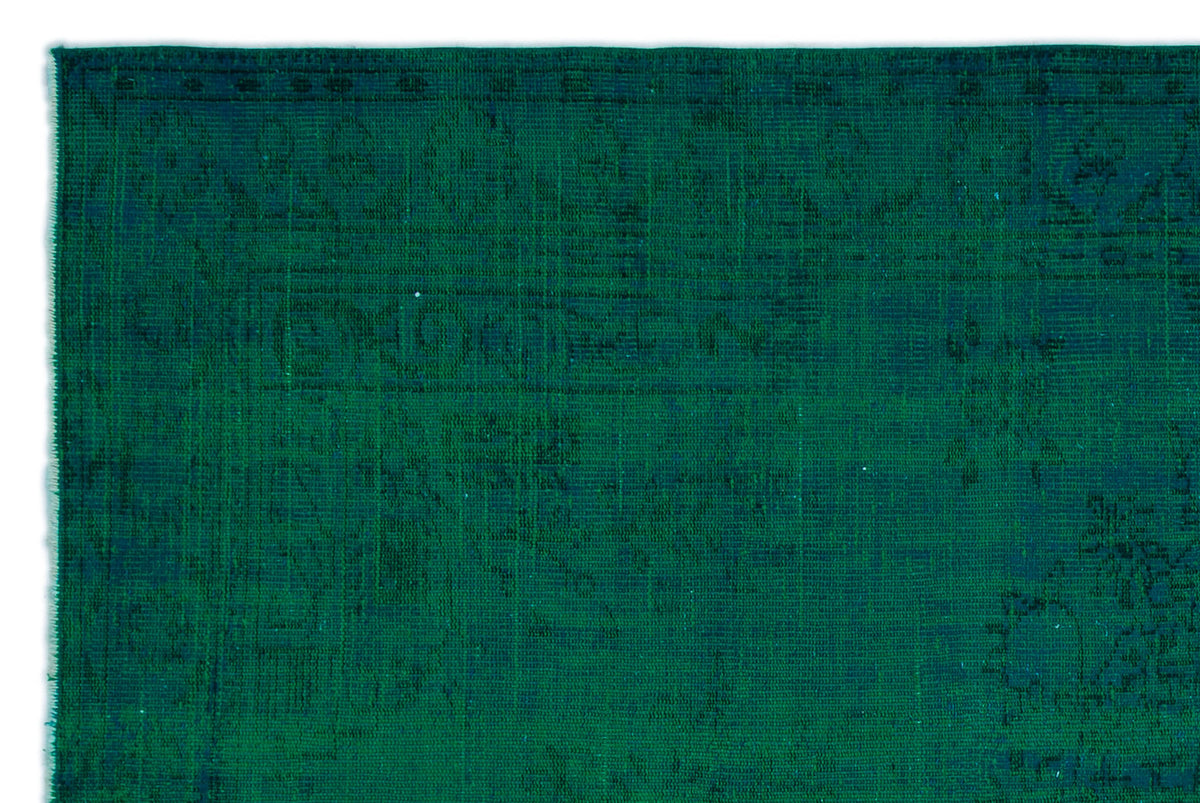 Deep emerald green rug with a subtle, distressed traditional medallion pattern.