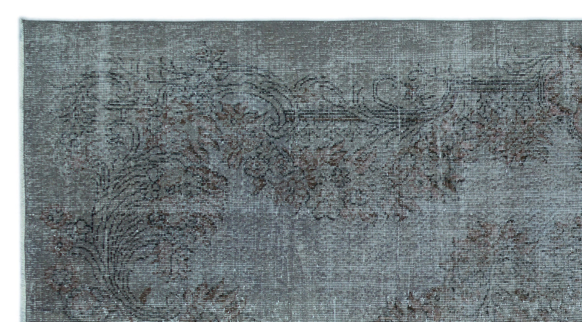 Distressed charcoal and grey rug with a faded floral medallion pattern.