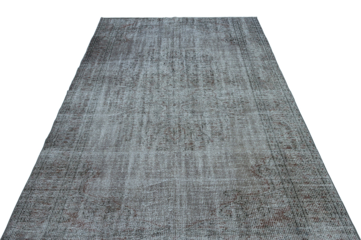 Grey and brown distressed vintage-style rug with a faded traditional medallion pattern on a white background.