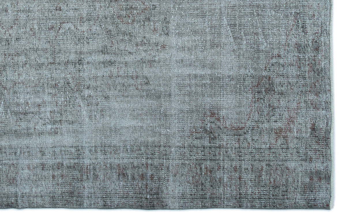 Blue-grey distressed rug with a faded traditional medallion pattern and visible woven texture.