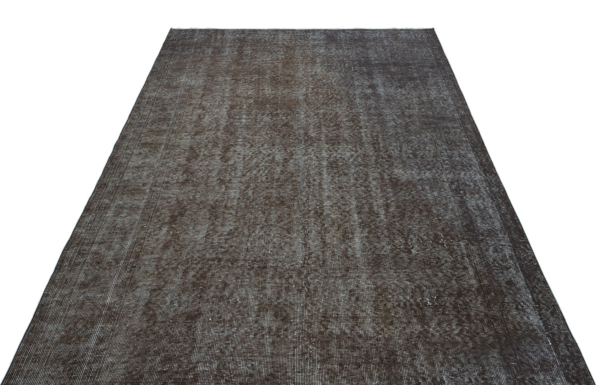 Dark brown distressed vintage-style rug with a faded, textured monochromatic pattern on a white background.