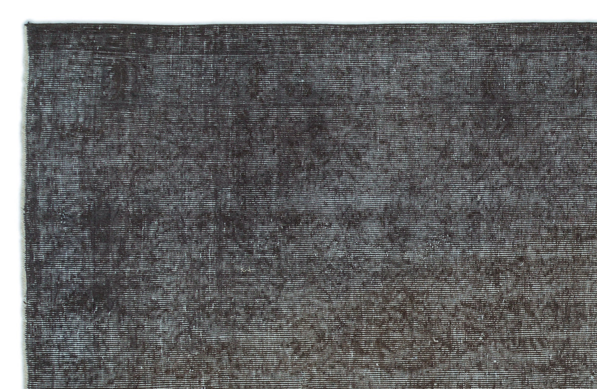 Dark charcoal and black distressed rug with a subtle, fine-lined texture.