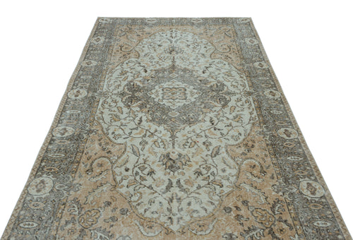 Load image 1 in gallery view. Distressed beige and grey traditional rug with a central floral medallion and ornate border on a white background.