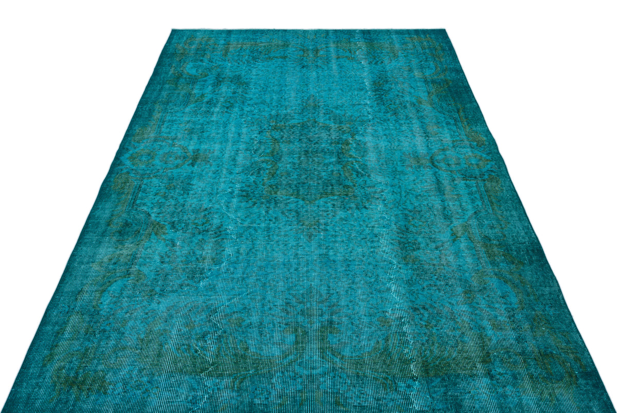 Teal and dark green distressed rug with a faded traditional medallion pattern on a white background.