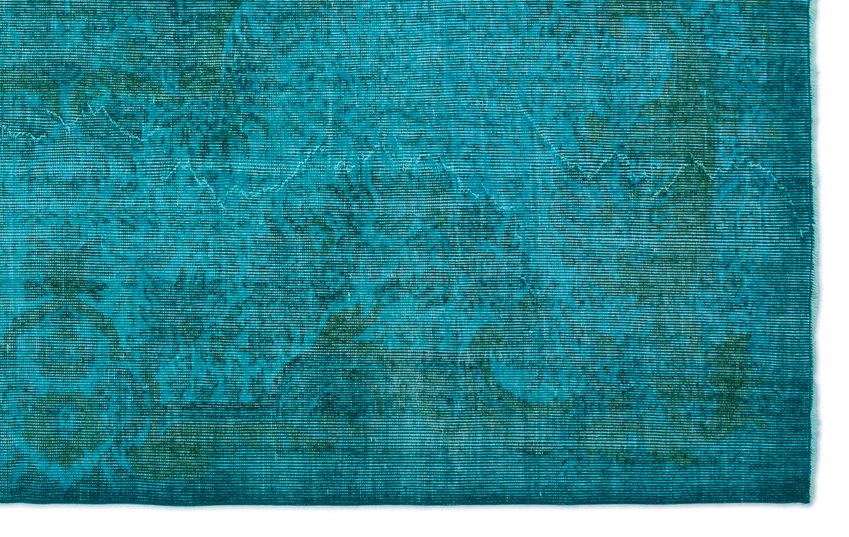 Teal and dark green rug with a distressed, faded traditional floral medallion pattern.