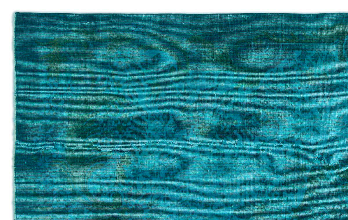 Teal and dark green distressed rug with a faint, overdyed traditional medallion pattern.