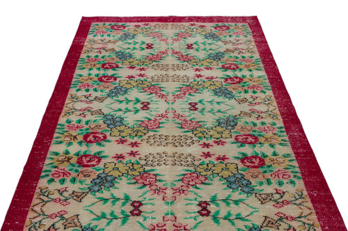 Load image 1 in gallery view. Beige vintage rug with a red border and a repeating floral pattern in red, yellow, blue, and green.