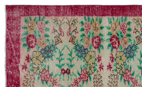 Load image 1 in gallery view. Beige rug with a distressed floral pattern in red, yellow, blue, and green, featuring a wide red border.