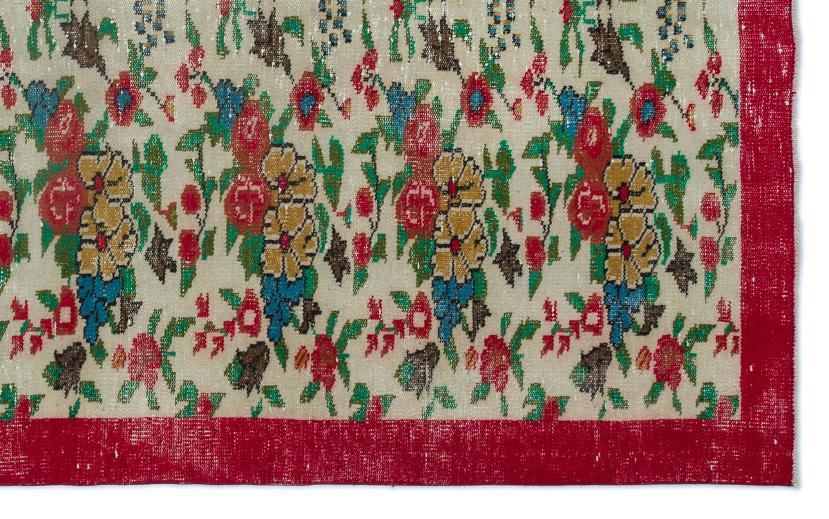 Cream rug with a distressed floral pattern in red, yellow, and blue, featuring a solid red border.