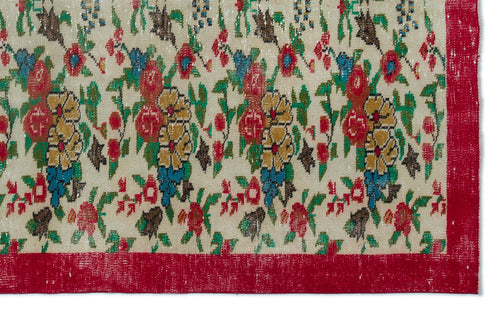 Load image 1 in gallery view. Cream rug with a distressed floral pattern in red, yellow, and blue, featuring a solid red border.