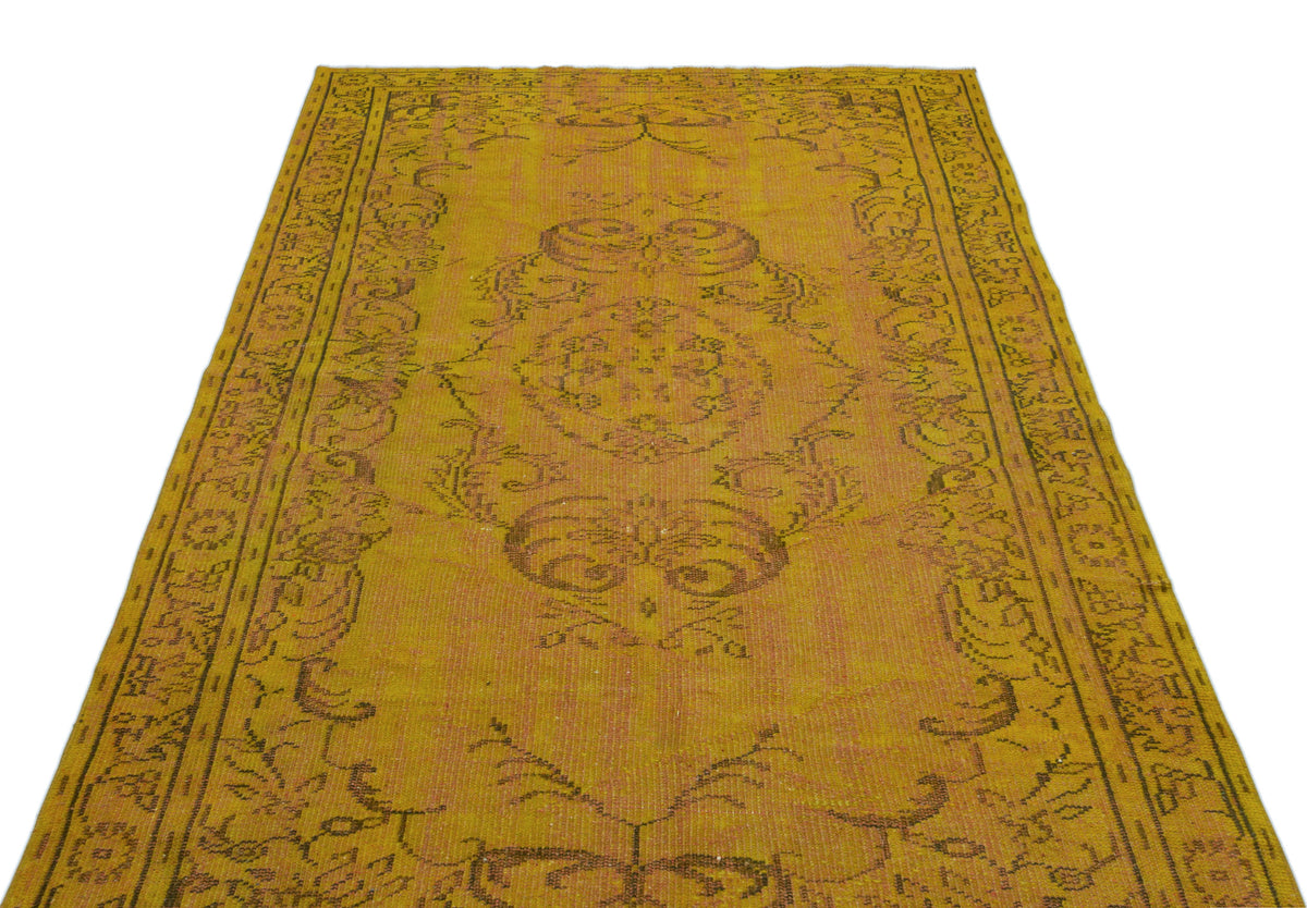 Mustard yellow vintage-style rug with a distressed central medallion and ornate border pattern on a white background.