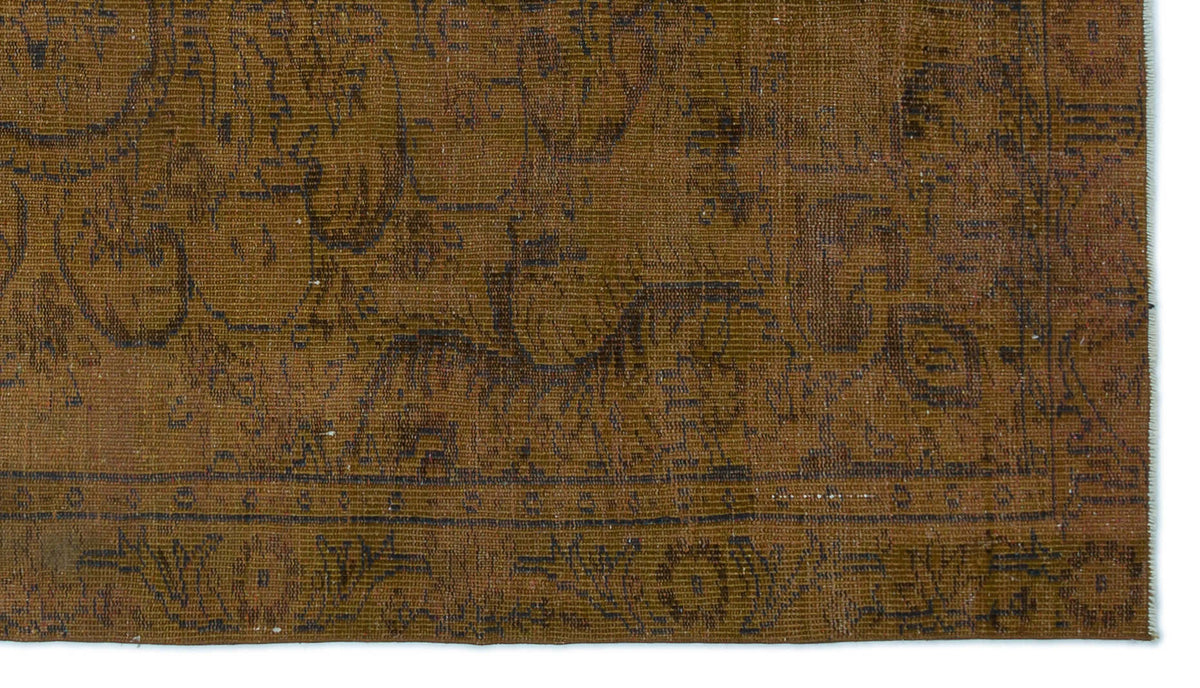Brown rug with a dark, distressed traditional floral medallion pattern and a bordered edge.