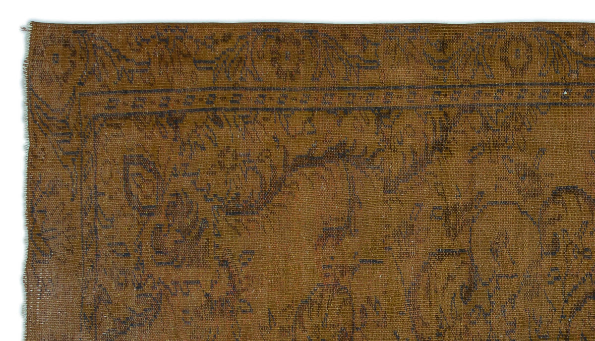 Brown vintage-style rug with a dark, faded floral medallion pattern and a linear border.