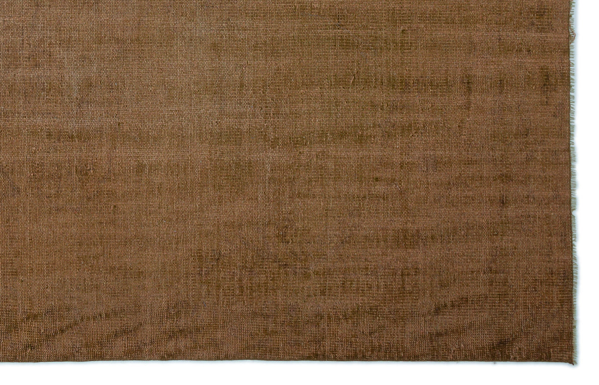 Solid brown, distressed-texture rug with a visible woven weave and frayed edge.