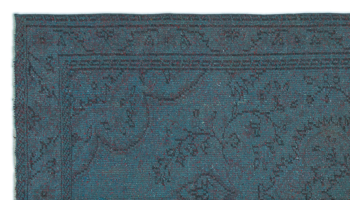 Teal blue rug with a dark, distressed traditional floral medallion pattern and a bordered edge.