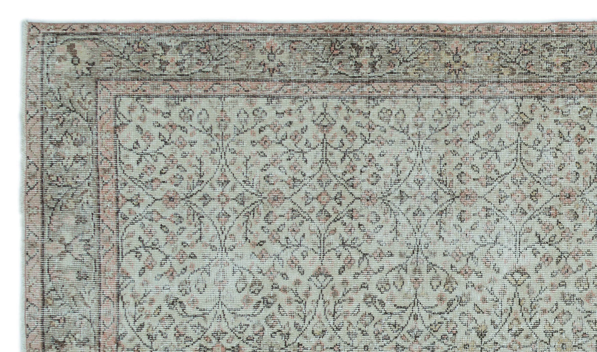 Sage green and dusty rose traditional rug with a distressed floral vine pattern and a decorative border.