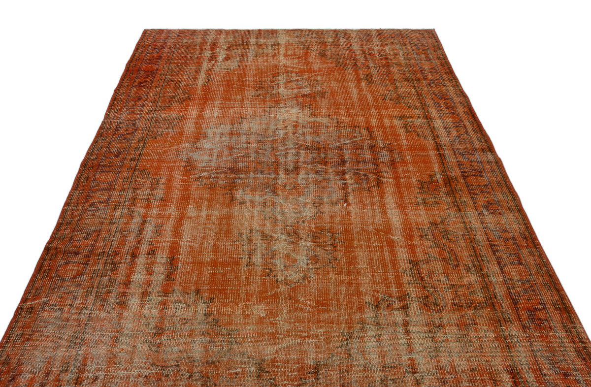 Distressed burnt orange vintage-style rug with a faded central medallion and intricate border pattern on white background.