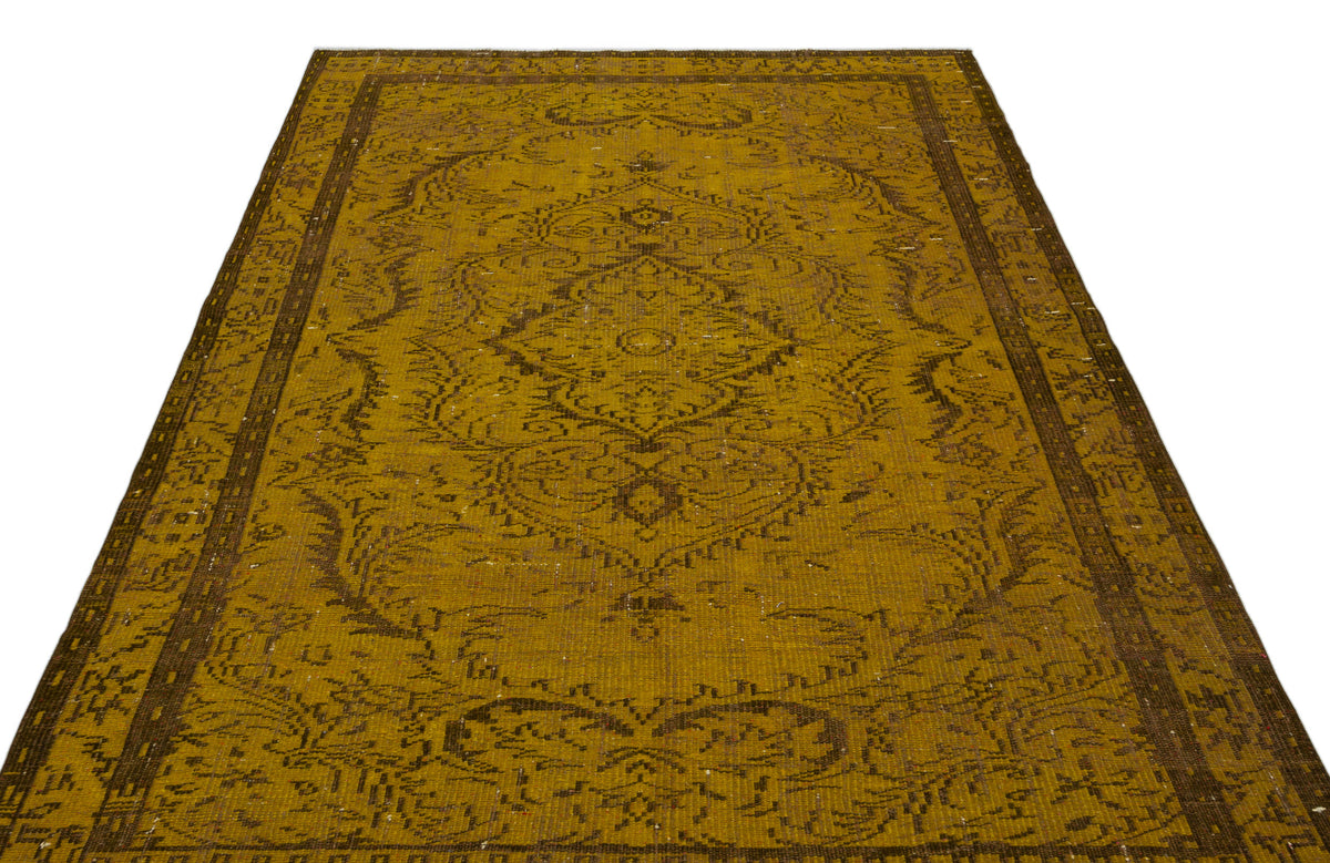 Mustard yellow and brown vintage-style rug with a central floral medallion and ornate border on a white background.