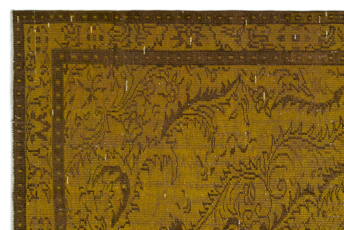 Mustard yellow and dark brown rug with a distressed traditional floral border and central medallion pattern.