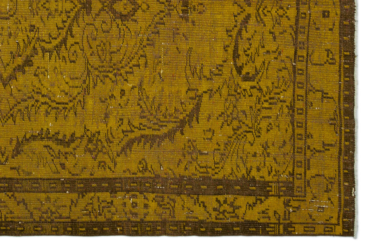 Mustard yellow and brown vintage-style rug with a distressed traditional floral pattern and a geometric border.