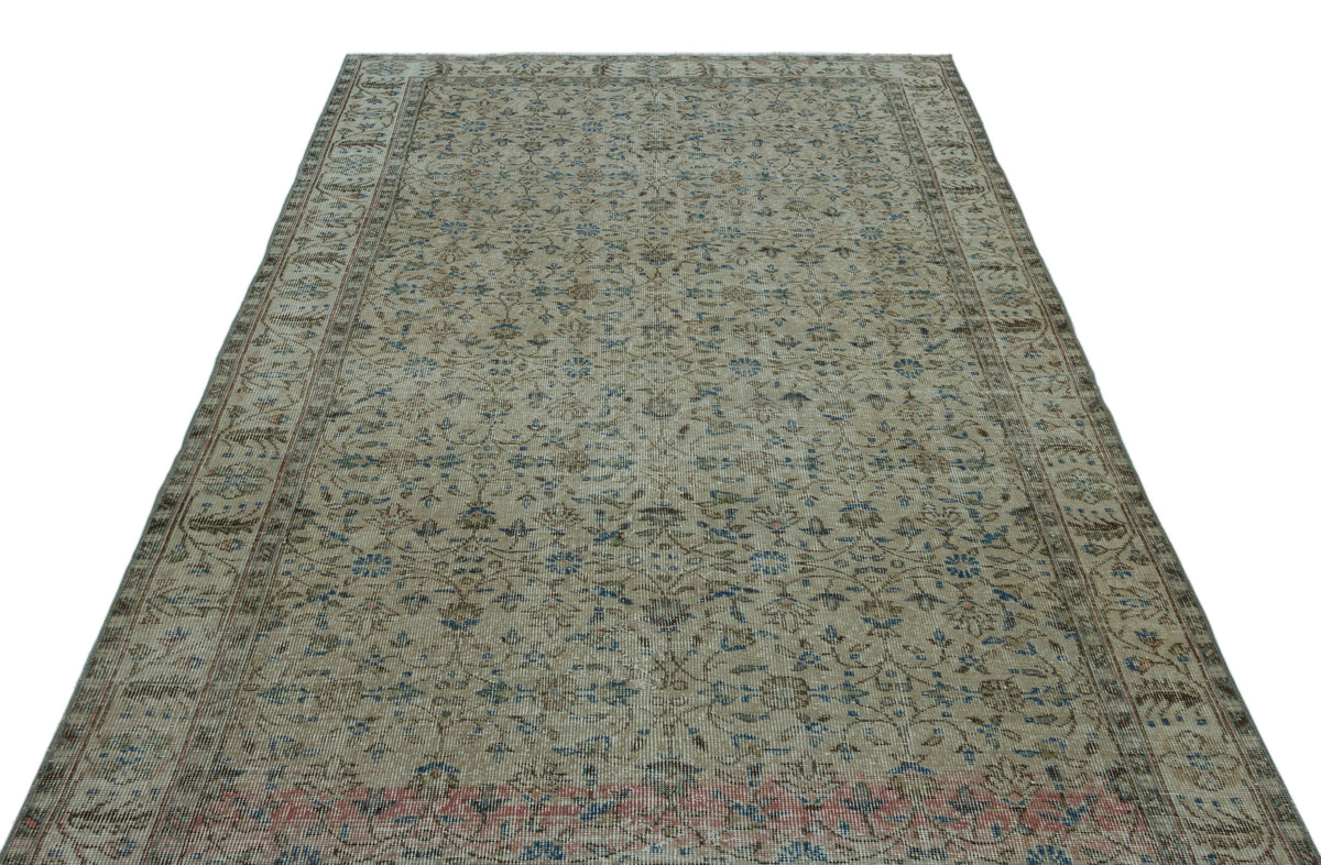 Beige vintage-style rug with a faded floral pattern in blue and brown, featuring a decorative border.