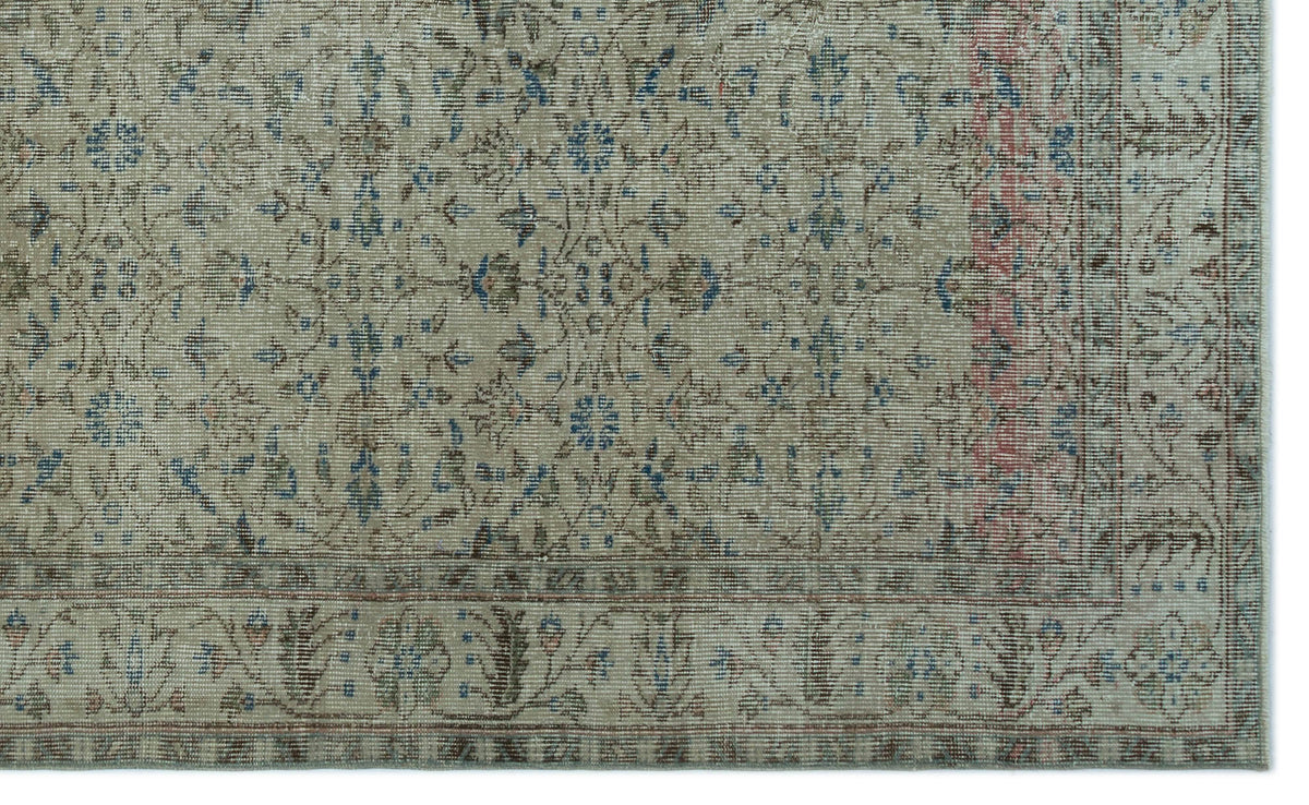 Beige vintage-style rug with a distressed floral medallion pattern in blue, brown, and muted red accents.