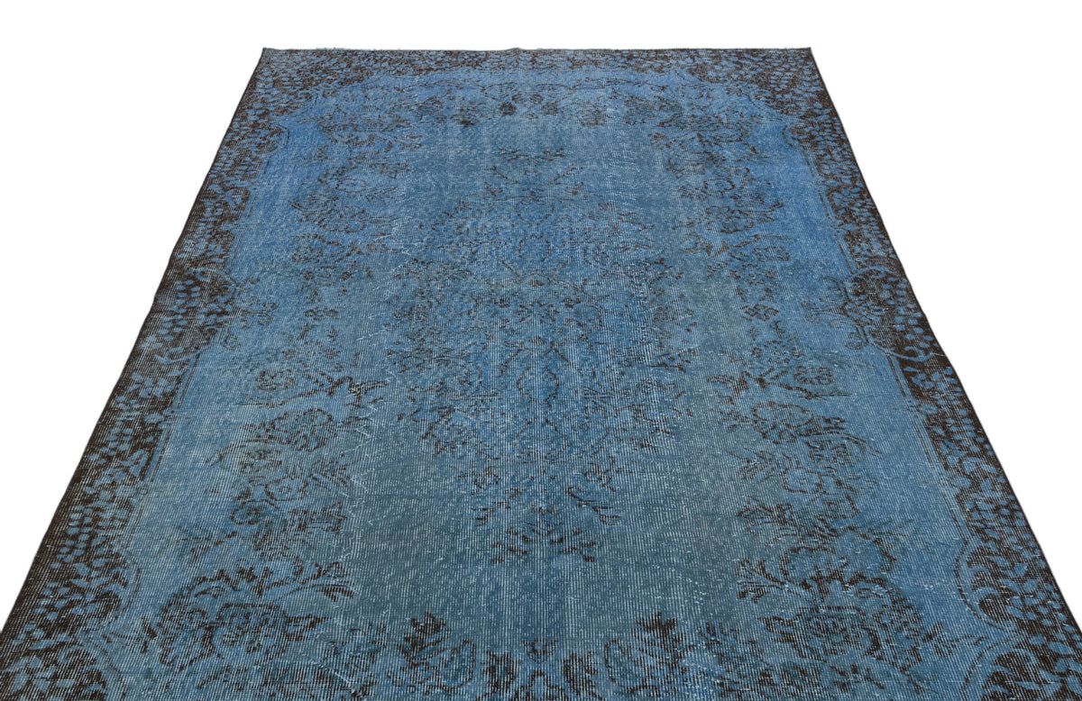 Blue and charcoal distressed traditional rug with a central floral medallion and ornate border on a white background.