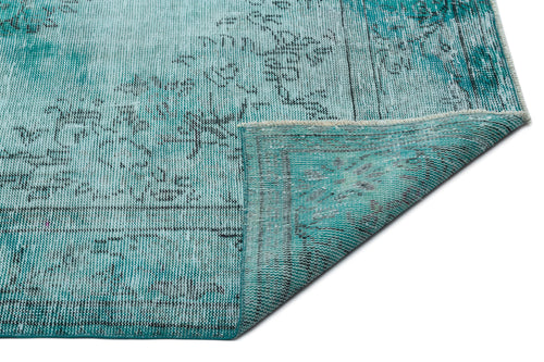 Load image 1 in gallery view. Distressed turquoise and black vintage-style rug with a folded corner revealing the woven backing.