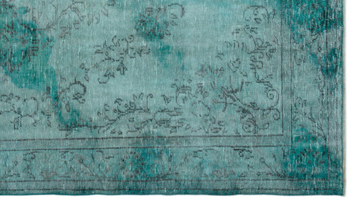 Load image 1 in gallery view. Teal and turquoise distressed rug with a faded black floral medallion pattern and a bordered edge.