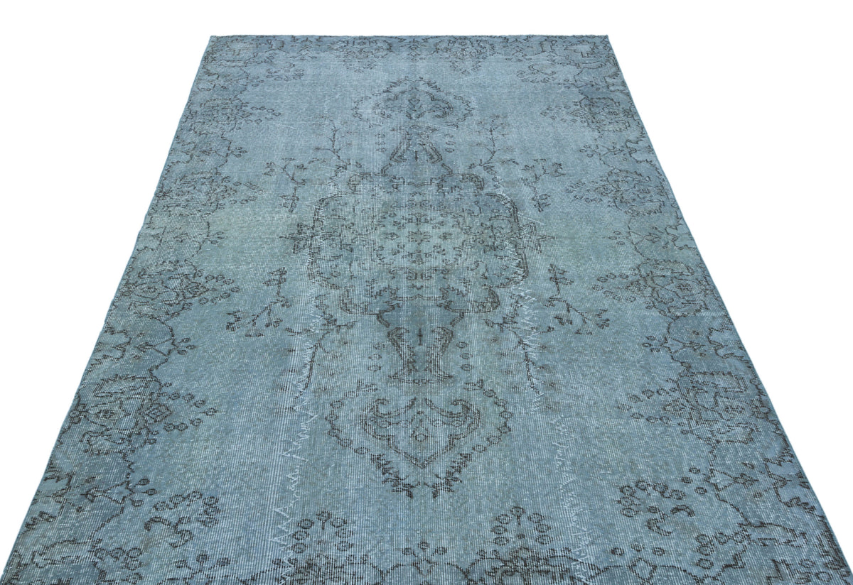 Light blue distressed rug with a dark grey traditional floral medallion pattern.